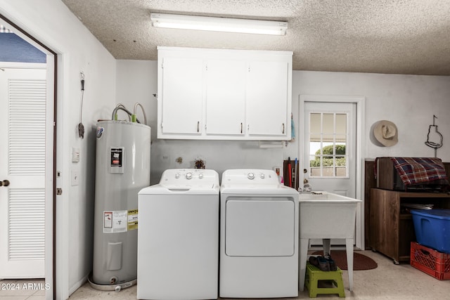 laundry room featuring cabinets, a textured ceiling, electric water heater, and washing machine and dryer