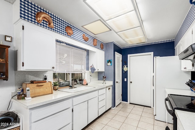 kitchen with light tile patterned flooring, range with electric cooktop, white cabinetry, and sink