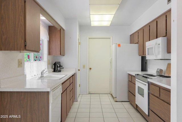 kitchen featuring sink, white appliances, and light tile patterned floors