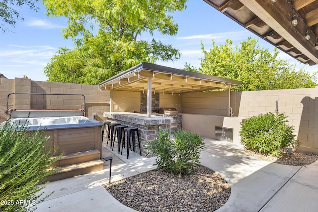6918 E Ivyglen St, Mesa, AZ 85207 - fenced backyard featuring a bar, a hot tub, exterior kitchen, and a patio area