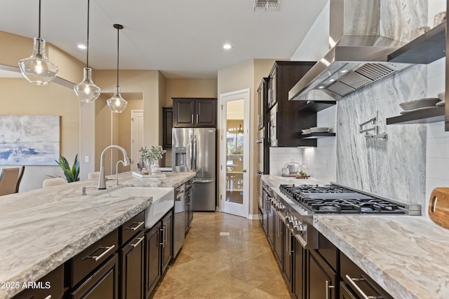 6918 E Ivyglen St, Mesa, AZ 85207 - kitchen with stainless steel appliances, a sink, wall chimney range hood, decorative backsplash, and dark brown cabinets