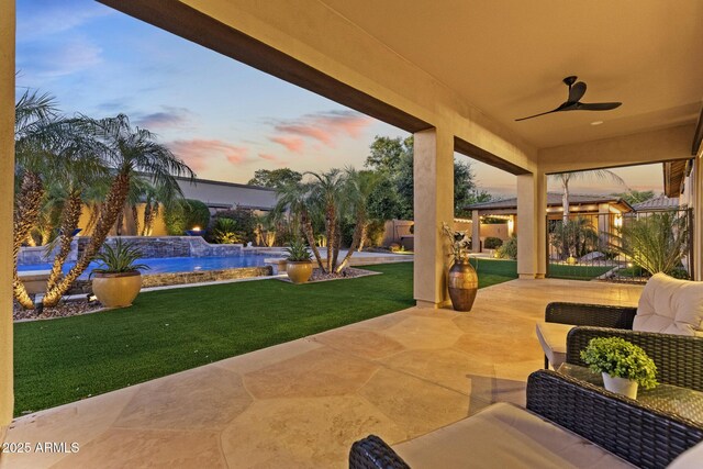6918 E Ivyglen St, Mesa, AZ 85207 - patio terrace at dusk featuring ceiling fan, an outdoor pool, and a patio