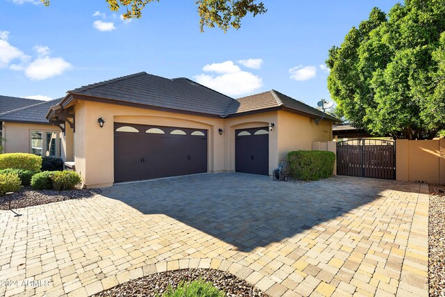 6918 E Ivyglen St, Mesa, AZ 85207 - ranch-style house featuring stucco siding, an attached garage, decorative driveway, a gate, and a tiled roof