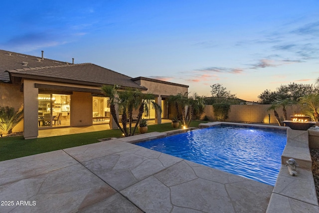6918 E Ivyglen St, Mesa, AZ 85207 - pool at dusk with a patio area, an outdoor fire pit, and a fenced backyard