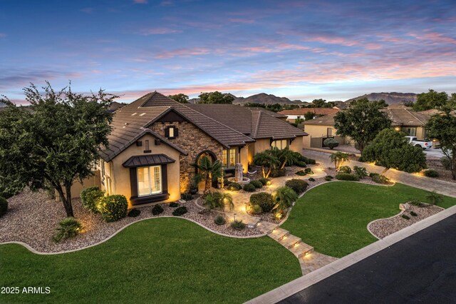 6918 E Ivyglen St, Mesa, AZ 85207 - view of front of house featuring stucco siding, stone siding, a front yard, and a tiled roof