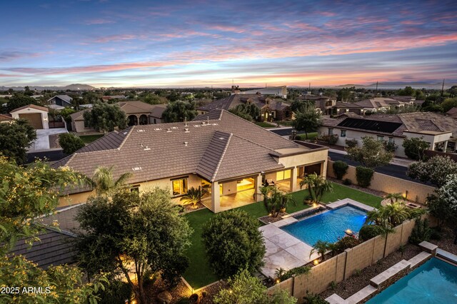 6918 E Ivyglen St, Mesa, AZ 85207 - pool at dusk with a fenced backyard, a residential view, and a patio