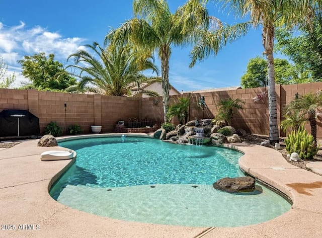 view of swimming pool with pool water feature and grilling area