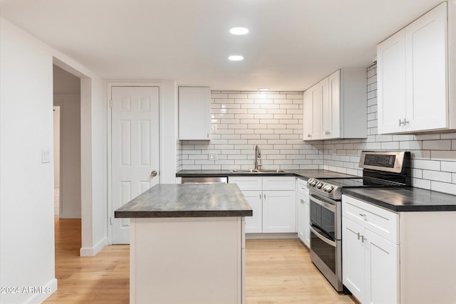 kitchen with a center island, range with two ovens, white cabinetry, and light hardwood / wood-style flooring