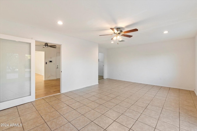 tiled empty room featuring ceiling fan