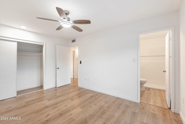 unfurnished bedroom featuring ceiling fan, a closet, ensuite bathroom, and light hardwood / wood-style floors