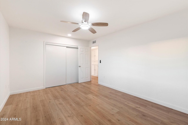 unfurnished bedroom featuring ceiling fan, a closet, and light hardwood / wood-style floors