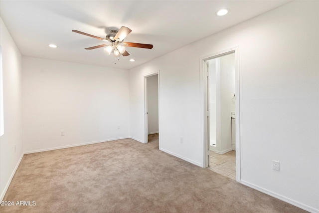 empty room featuring light colored carpet and ceiling fan