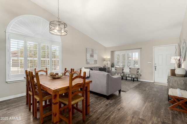 dining space with baseboards, dark wood-type flooring, a chandelier, and lofted ceiling