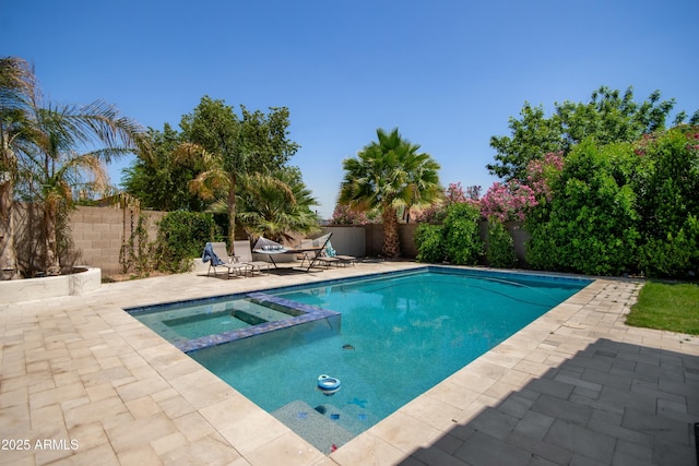 view of swimming pool featuring a patio, a pool with connected hot tub, and a fenced backyard