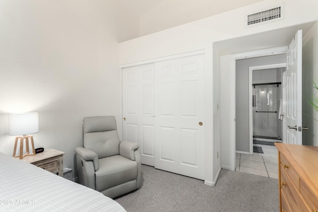 bedroom with light colored carpet, visible vents, baseboards, a closet, and light tile patterned flooring