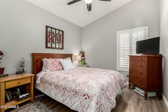 bedroom featuring baseboards, ceiling fan, wood finished floors, and lofted ceiling