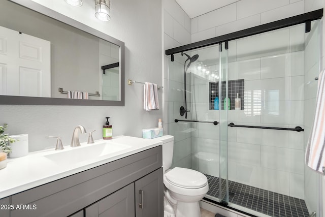 full bath with vanity, toilet, and a stall shower