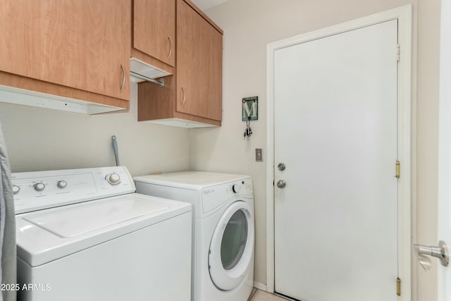 clothes washing area featuring cabinet space and washer and dryer