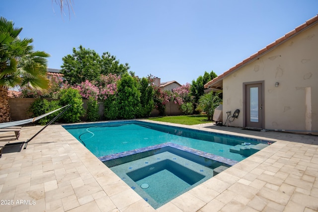 view of pool featuring a fenced backyard, a patio area, and a pool with connected hot tub