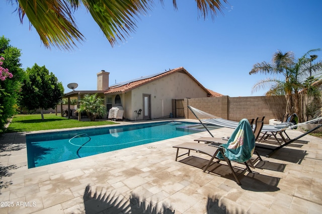 view of pool featuring a fenced in pool, a fenced backyard, a lawn, and a patio