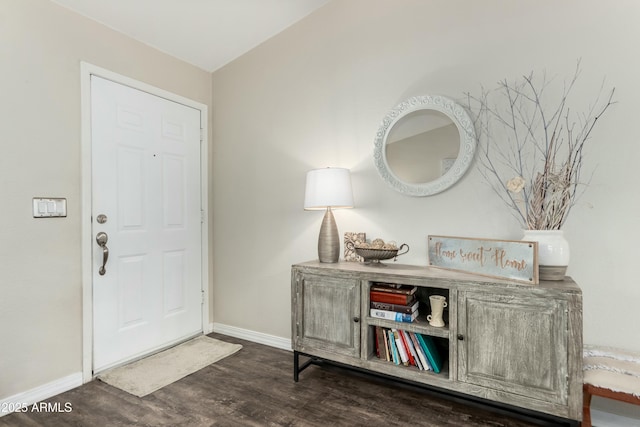 foyer featuring baseboards and wood finished floors