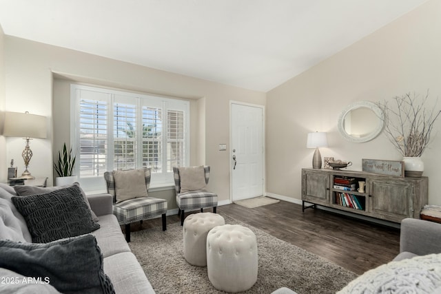 living area featuring baseboards, wood finished floors, and vaulted ceiling