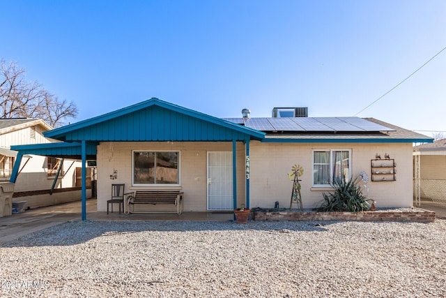 view of front facade with covered porch and solar panels