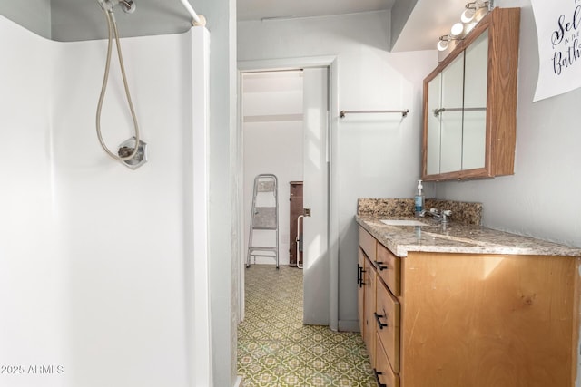 full bathroom featuring vanity, tile patterned floors, and a shower