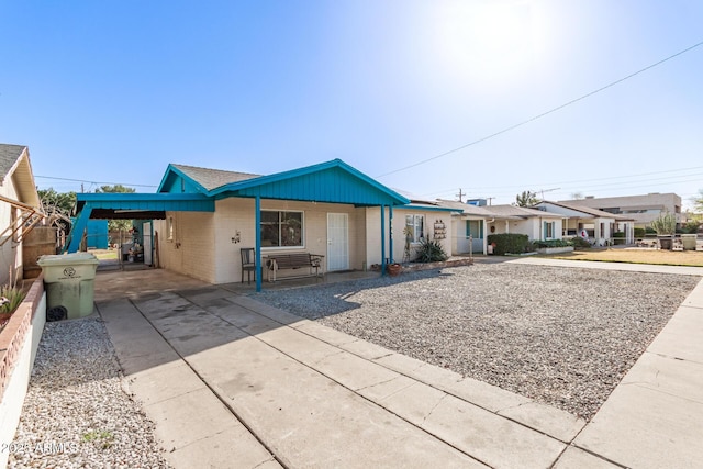 view of front of property featuring an attached carport, concrete driveway, and a porch