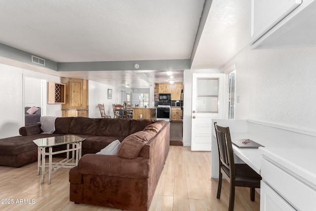 living area with visible vents and light wood finished floors