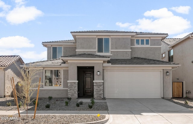 prairie-style home with concrete driveway, a tiled roof, an attached garage, and stucco siding