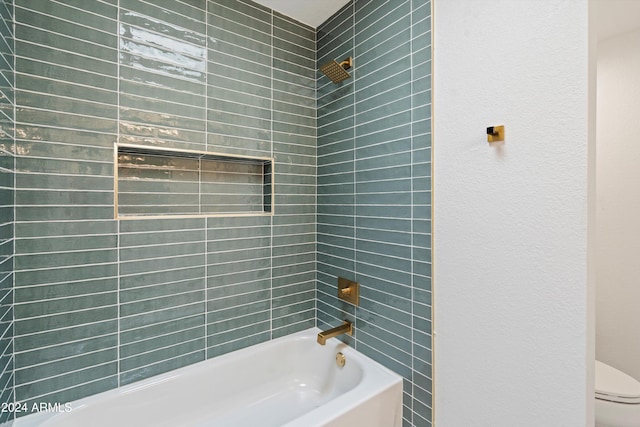 bathroom with tiled shower / bath and toilet