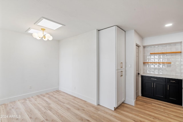 interior space with light wood-type flooring and a chandelier