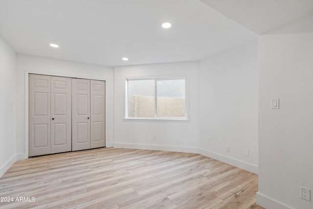 unfurnished bedroom featuring light hardwood / wood-style flooring and a closet