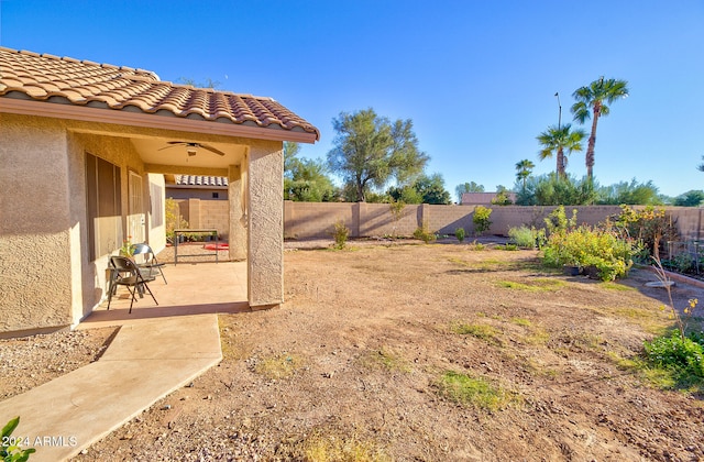 view of yard featuring ceiling fan and a patio