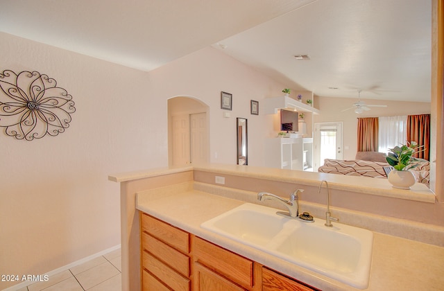 kitchen featuring light tile patterned floors, ceiling fan, sink, and lofted ceiling