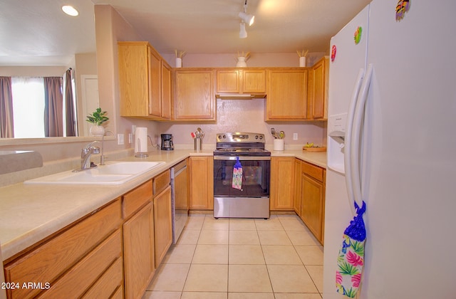 kitchen with light brown cabinets, appliances with stainless steel finishes, sink, and light tile patterned flooring