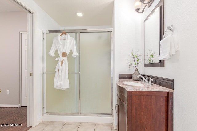 bathroom with vanity, a shower with shower door, and tile patterned floors