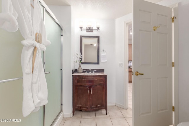 bathroom with vanity, tile patterned floors, a textured ceiling, and a shower with shower door