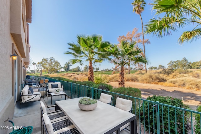 view of patio with a balcony, an outdoor living space, and a rural view