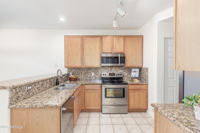 kitchen featuring stainless steel appliances, kitchen peninsula, sink, and light brown cabinets