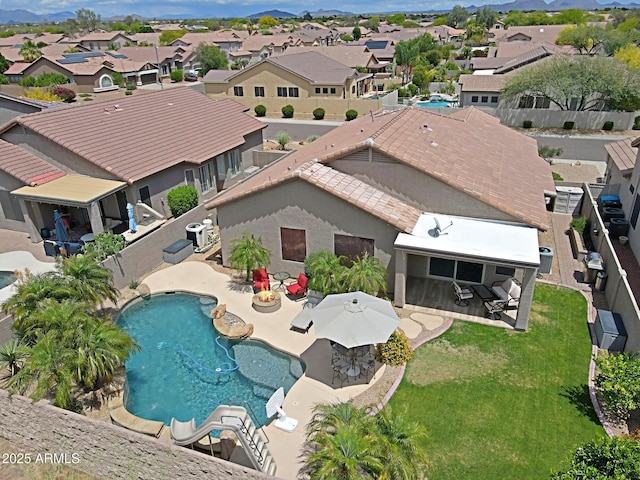 aerial perspective of suburban area with a mountainous background and a pool area