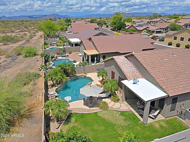 aerial perspective of suburban area featuring a pool and mountains