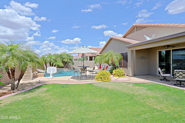 view of yard featuring a patio area, ceiling fan, and stairway