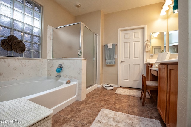 bathroom with tile patterned flooring, independent shower and bath, and vanity