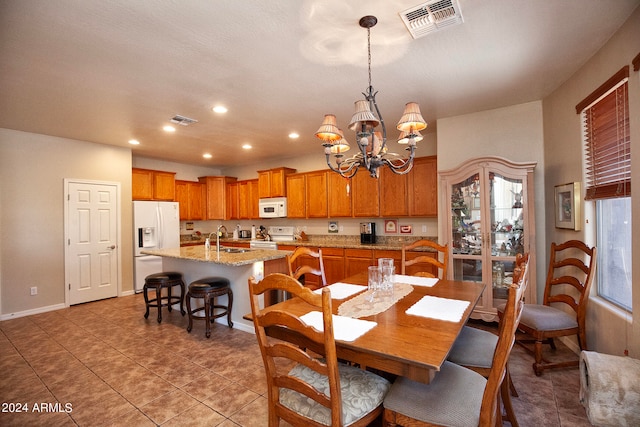 dining area with tile patterned floors, a notable chandelier, and sink