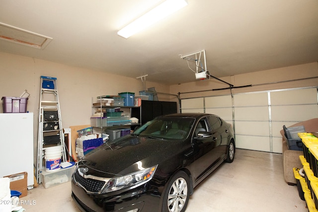 garage with a garage door opener and white refrigerator