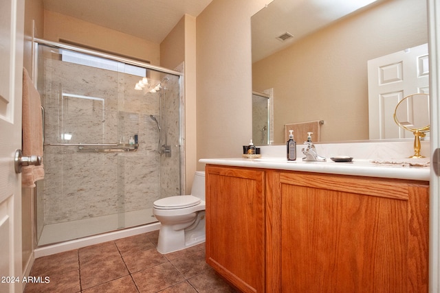 bathroom featuring tile patterned floors, toilet, an enclosed shower, and vanity