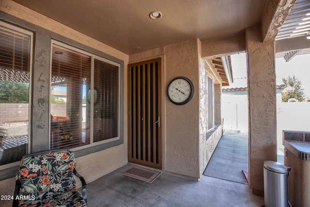 view of exterior entry with a pergola