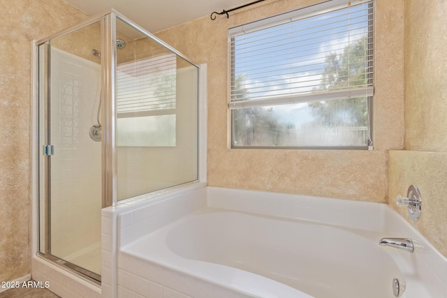 bathroom with a shower stall and a bath